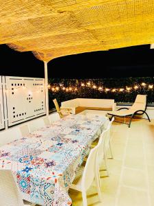 een tafel en stoelen op een balkon met verlichting bij Vacanza Azzurra in Porto Cesareo
