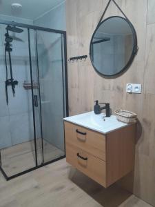 a bathroom with a sink and a shower with a mirror at Pokoje Bory Tucholskie in Tuchola