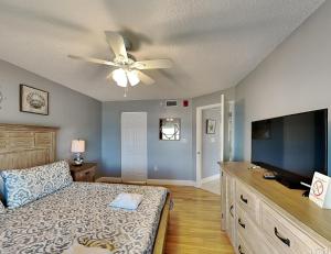 a bedroom with a bed and a flat screen tv at Sea Winds 602 in Ormond Beach +11 photos