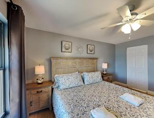 a bedroom with a bed and a ceiling fan at Sea Winds 602 in Ormond Beach