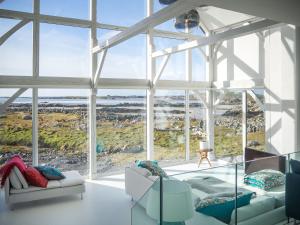 una sala de estar con una gran ventana de cristal en Doleen Quay House, en Ballyconneely