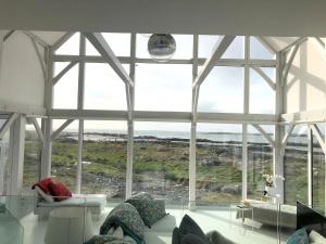 una sala de estar con una gran ventana de cristal en Doleen Quay House, en Ballyconneely