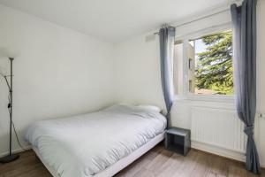 una camera con letto e finestra di Le Montigny Chic a Montigny-le-Bretonneux