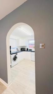 a kitchen with an archway in a white kitchen at New fully furnished cosy home in Balderton