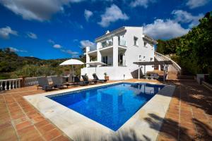 Villa con piscina frente a una casa en Exquisite and Modern villa near beach with Heated pool!, en Marbella