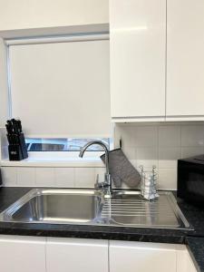 a kitchen counter with a sink in a kitchen at New fully furnished cosy home in Balderton