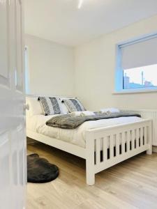 a white bed in a room with a window at New fully furnished cosy home in Balderton