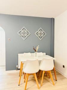 a dining room with a white table and chairs at New fully furnished cosy home in Balderton