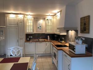 Upgant-SchottにあるFerienhaus Mare Frisicumのキッチン(白いキャビネット、シンク、コンロ付)