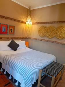 a bedroom with a bed and a bench in it at Riad Tafilag in Taroudant