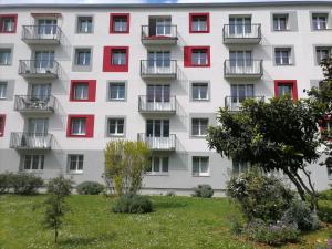 un edificio de apartamentos con ventanas rojas y blancas en Le Rosier - 20 min de Paris et d'Orly, en Vitry-sur-Seine