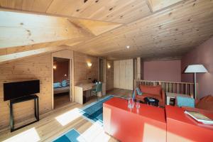 a living room with a red couch and a tv at Seiser Alm Urthaler in Alpe di Siusi