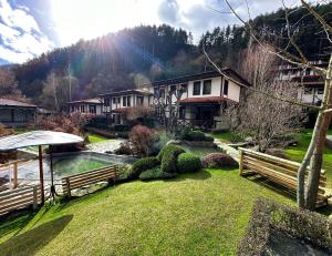 uma casa com um lago no meio de um quintal em Spa Hotel Ismena em Devin