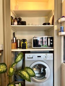 una cocina con lavadora en una despensa en Carla’s Résidences Studio Hyper Centre, en Aix-les-Bains