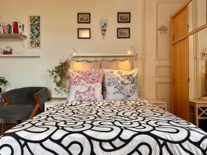 1 dormitorio con cama blanca y negra con almohadas en Carla’s Résidences Studio Hyper Centre, en Aix-les-Bains