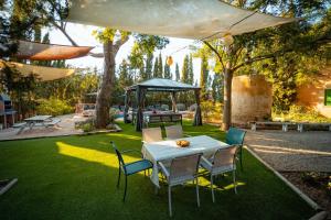a table and chairs in a garden with a gazebo at Catalunya Casas Rustic Vibes Villa with private pool 12km to beach in Vilafranca del Penedès