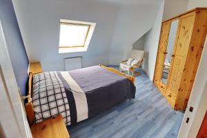 ein Schlafzimmer mit einem Bett, einem Fenster und einem Stuhl in der Unterkunft 688-Villa de la Baie a 300m de la plage in Audierne