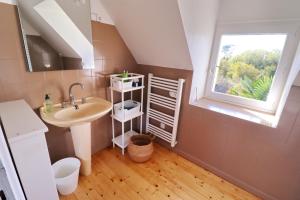 un bagno con lavandino e finestra di 698-Villa du Fautec Proche plages a Plouhinec Altre 28 foto