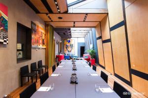 une grande salle à manger avec de longues tables et chaises dans l'établissement Tolarno Hotel - Chambre Boheme - Australia, à Melbourne