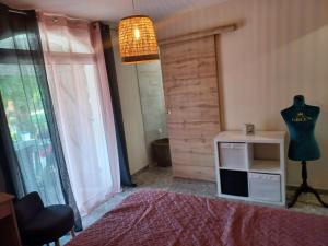- une chambre avec un lit et une table avec une commode dans l'établissement villa serignan, à Sérignan