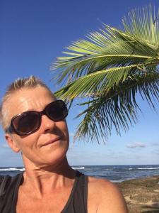 Una donna anziana con gli occhiali da sole in piedi accanto a una palma. di Casa Mona, Jungle vibes adults only a Cocles