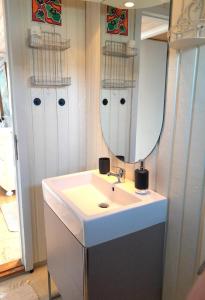 La salle de bains est pourvue d'un lavabo et d'un miroir. dans l'établissement The Beach House, à Haderslev