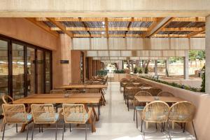 an empty restaurant with wooden tables and chairs at Camping Cala Pola in Tossa de Mar