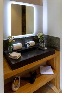 bagno con lavandino nero e specchio di La Limetière a Neuvy-le-Roi
