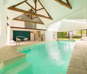 una grande piscina con acqua blu in una casa di La Limetière a Neuvy-le-Roi