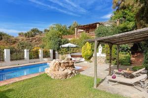 une arrière-cour avec une piscine et une maison dans l'établissement Aguada, à Frigiliana