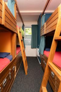 a room with three bunk beds and a window at Haka Lodge Auckland in Auckland