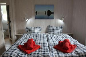 2 camas con toallas rojas en un dormitorio en Ferienhaus Schatzkiste 18 - b51139, en Lübeck