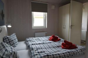 1 dormitorio con 2 toallas rojas en una cama en Ferienhaus Schatzkiste 18 - b51139, en Lübeck