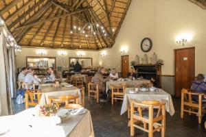 a group of people sitting at tables in a restaurant at La La Nathi Country Guesthouse in Harrismith