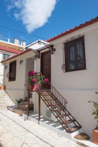 a white house with a staircase with pink flowers at Katerina 1 Bedroom House in Zakynthos