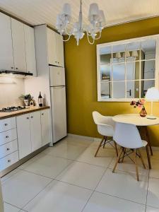 a kitchen with white cabinets and a table and chairs at Katerina 1 Bedroom House in Zakynthos Town