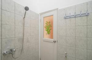 uma casa de banho com um chuveiro e uma porta com um quadro em Graha Aditya Syariah em Palimbão