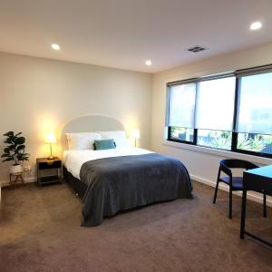 a bedroom with a bed and a large window at Altona entire 3 bedrooms house in Altona