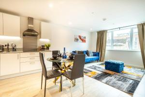 a kitchen and living room with a table and chairs at Comfy 2-Bed Flat in Dartford, Kent. in Kent