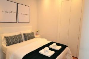 リスボンにあるGuestReady - Lemon House with Private Gardenのベッドルーム1室(ベッド1台、タオル2枚付)
