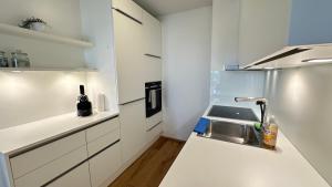 uma cozinha branca com um lavatório e um frigorífico em Wiener Townhouse Staatsoper em Viena