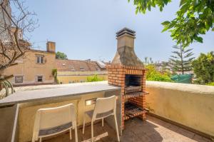 einen Backsteinofen auf dem Dach mit zwei Stühlen in der Unterkunft GuestReady - Lemon House with Private Garden in Lissabon
