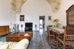 een woonkamer met een tafel en een bank bij Casa Beatrice in Caprarica di Lecce