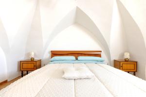 1 dormitorio con 1 cama blanca y 2 mesitas de noche en Casa Beatrice, en Caprarica di Lecce