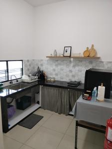 una cucina con lavandino e una scrivania con computer di ART CASIA HOMESTAY BERTAM a Kepala Batas