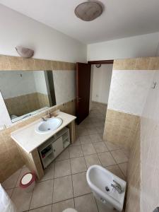 ein Bad mit einem Waschbecken und einem Spiegel in der Unterkunft Santu Marcu apartment in Decimomannu