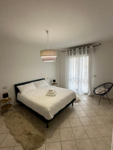 ein Schlafzimmer mit einem großen Bett und einem Stuhl in der Unterkunft Santu Marcu apartment in Decimomannu