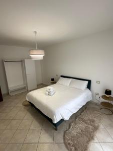 ein Schlafzimmer mit einem großen weißen Bett mit einer weißen Decke in der Unterkunft Santu Marcu apartment in Decimomannu