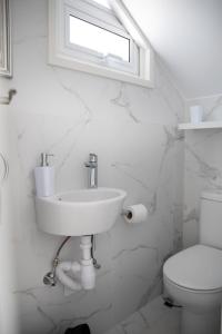 a white bathroom with a sink and a toilet at Taheli Riverside Townhouse in Tourist Area in Paphos City