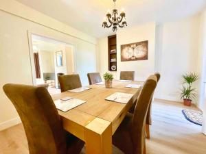 uma sala de jantar com uma mesa de madeira e cadeiras em The Lancaster - relax and enjoy home near City Center with parking em Canterbury